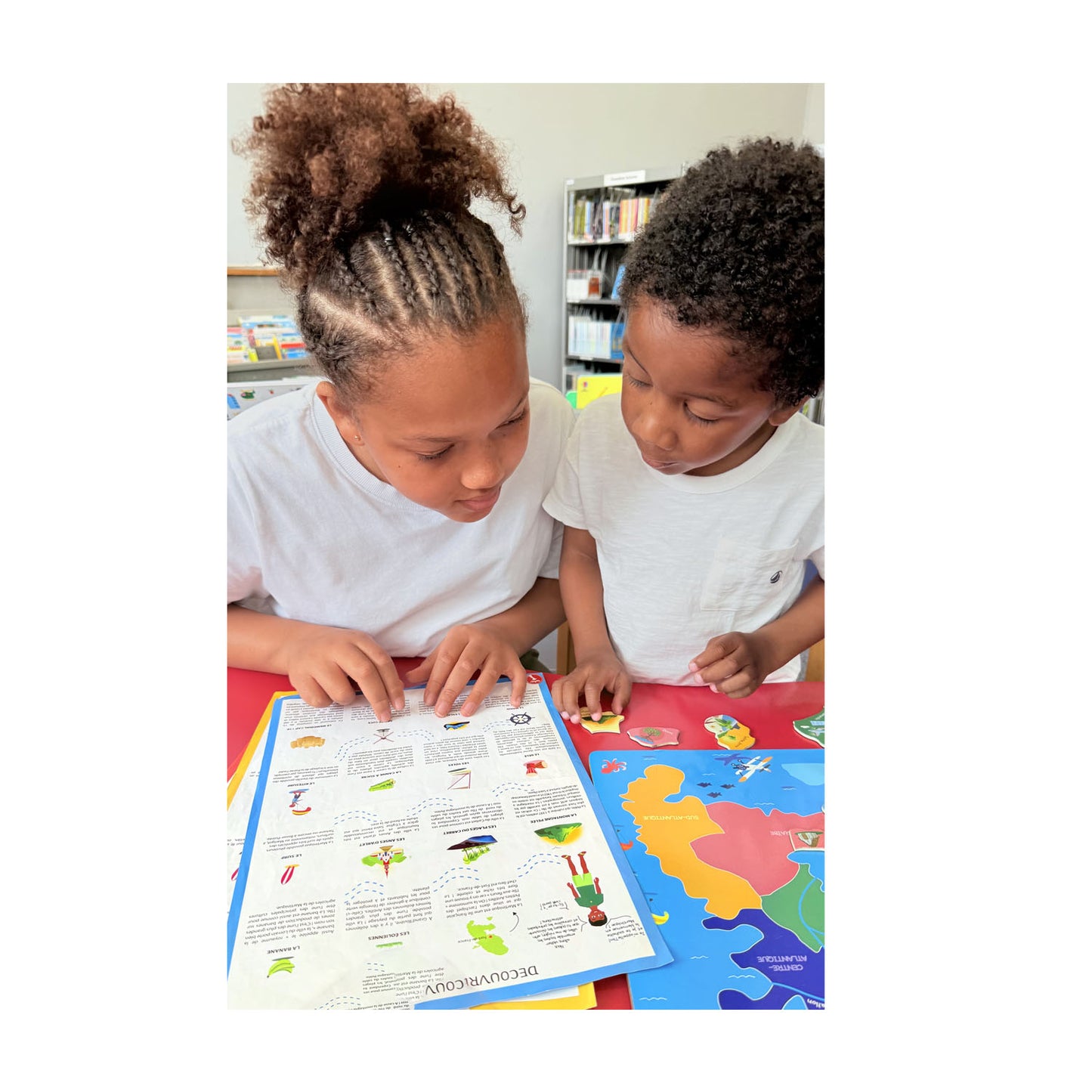 Deux enfants découvrant le livret éducatif trilingue du puzzle Martinique Yohel — jeu pédagogique sans écran dès 4 ans